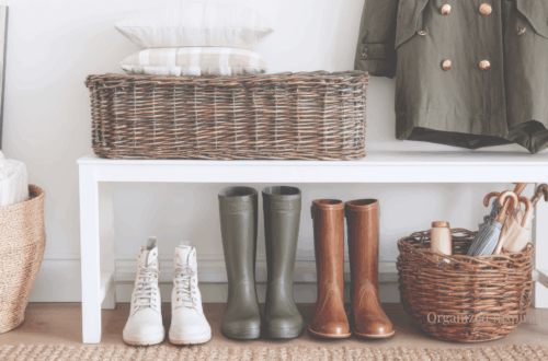 Minimal entryway with woven baskets, rain boots, and a neatly folded coat in soft natural light.